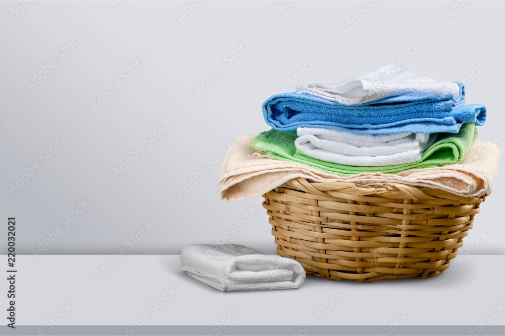 Laundry Basket with colorful towels on background Laundry Basket with colorful towels on background