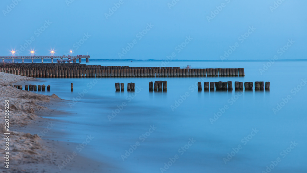 smooth sea surface and coast in blue twilight on long exposure