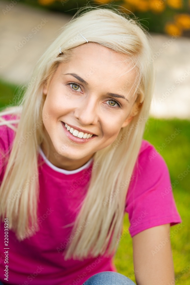 Portrait of a Smiling Young Woman in a Park