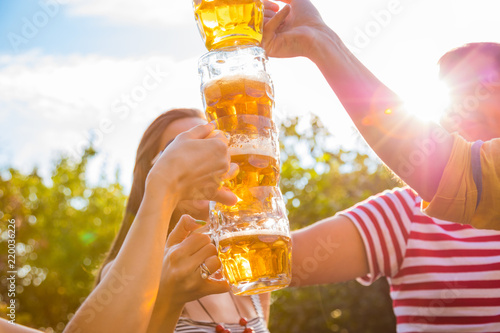 Group of young people enjoying outdoors with beer.