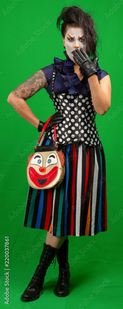 Female creepy clown standing. Isolated on green screen.