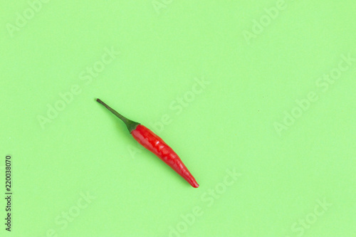 Red chili pepper. Top view on green background