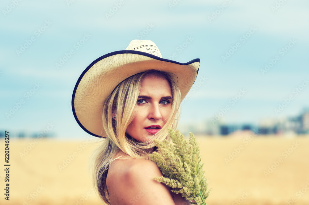 Portrait of a young woman in nature, a woman in a hat on a country walk
