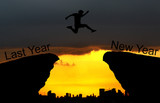A young man jump between Last year and new years over the sun and through on the gap of hill silhouette evening colorful sky. happy new year 2019.