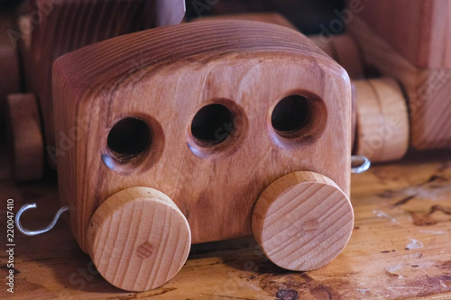 Wooden toy car trailer on the table in the workshop. photo