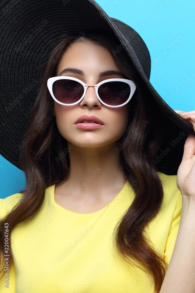 Fashion portrait of young woman wearing hat and sunglasses. Fashion portrait of young woman wearing hat and sunglasses.