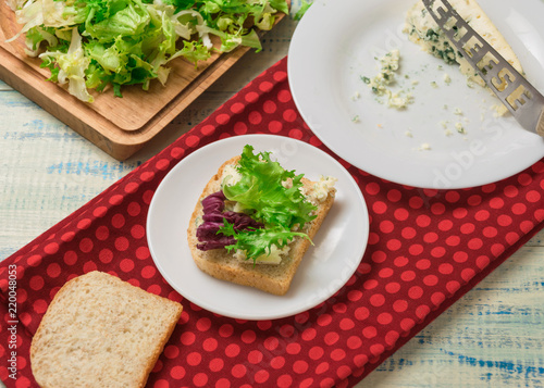 Vegetarian sandwich with salad and blue cheese on a wooden background. Healthy Diet