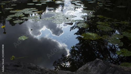 Time-lapse of clouds moving in the reflection of a lake, in a Swedish forest, in the Nackareservatet nature reserve. photo