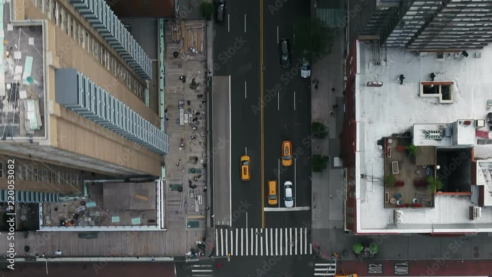 aerial passing over intersection with cars and taxis driving in traffic Midtown Manhattan New York City NYC