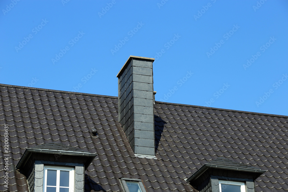 Neu gedecktes Dach mit Kaminverkleidung aus Schieferplatten