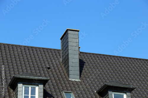 Neu gedecktes Dach mit Kaminverkleidung aus Schieferplatten