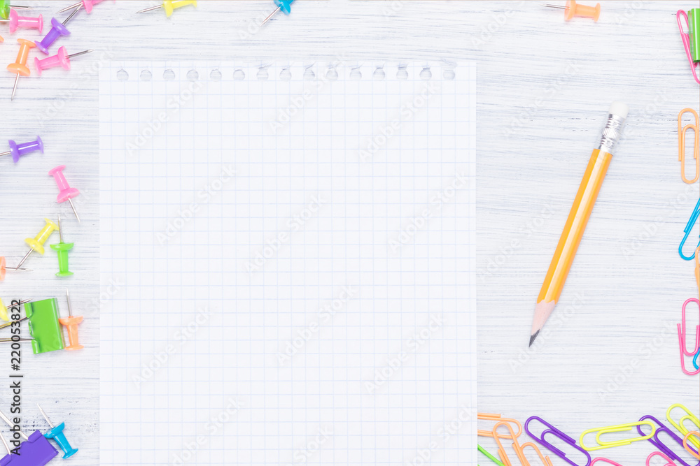 white sheet for notes and a pencil, around many different office supplies white sheet for notes and a pencil, around many different office supplies