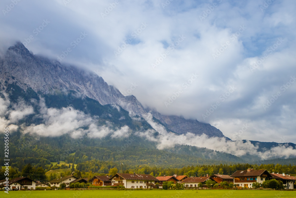 Grainau, Germany with the cloudy Alps mountains in the background at summer sunlight