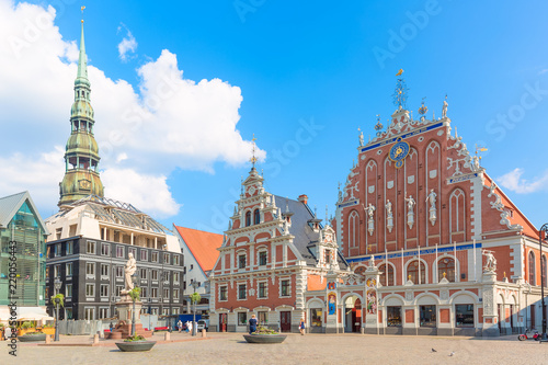 View of the Old Town square, Roland Statue, The Blackheads House and St Peters Cathedral against blue sky in Riga, Latvia. Summer sunny day