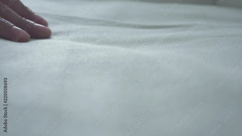 Hand of a woman is touching very soft and clean bed linen. Hand of a woman is touching very soft and clean bed linen.