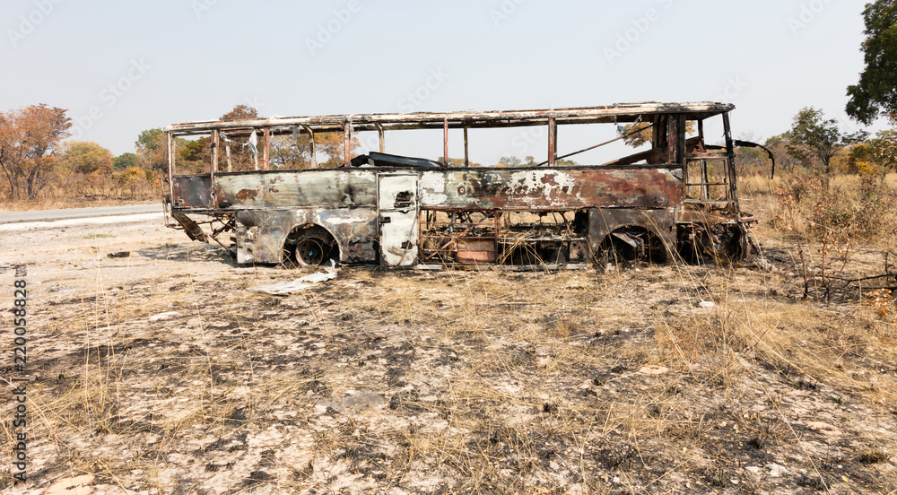 Burned bus at the side of the road