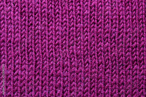 Knitted knitting needles from purple threads background