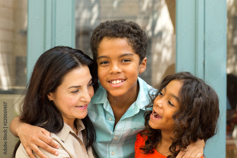 Happy Hispnaic mother laughing and talking with her children.