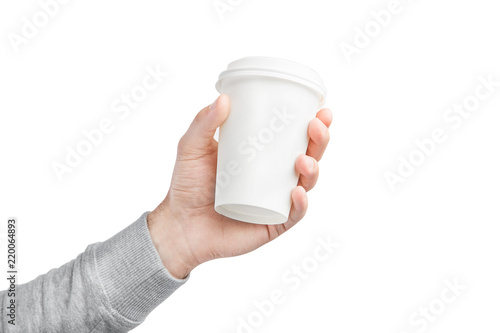 A paper cup of coffee in the hand. White paper cup of coffee in hand. For mock up. Isolated