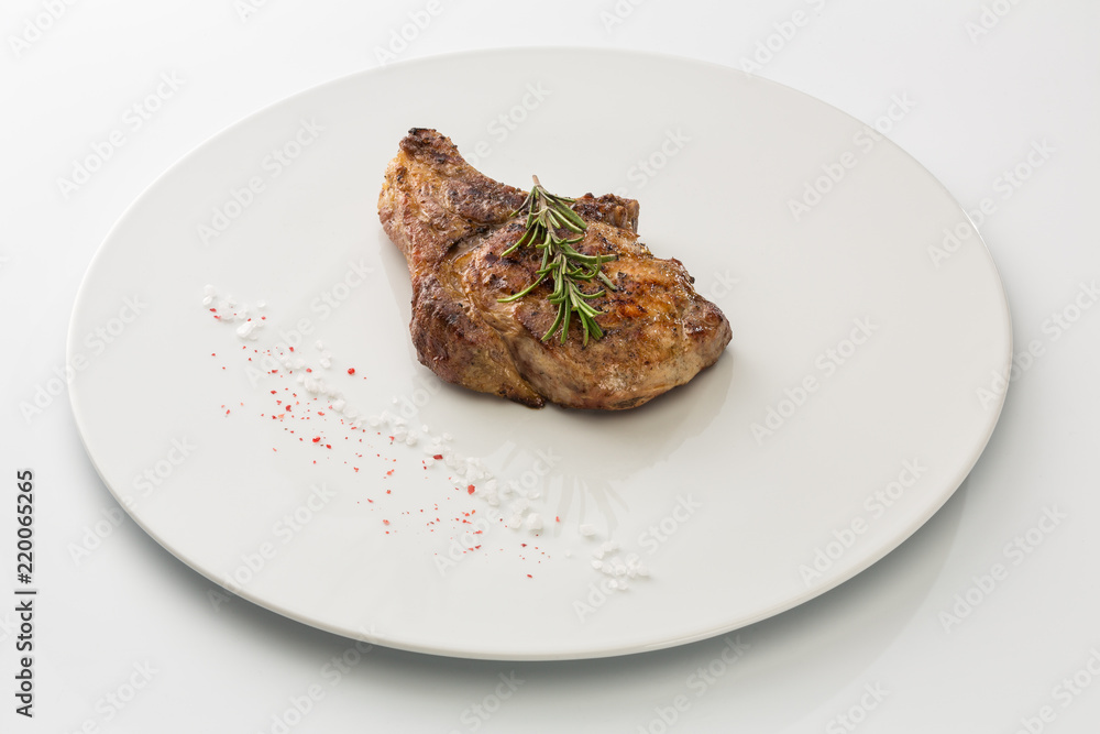 steak with salt and rosemary on a plate isolated on white background steak with salt and rosemary on a plate isolated on white background