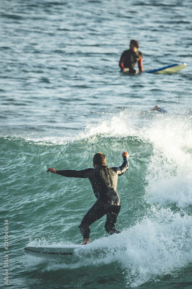 Mid aged surfer riding a wave on a sunny summer afternoon Mid aged surfer riding a wave on a sunny summer afternoon