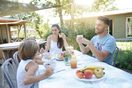 Family having breakfast in summer morning