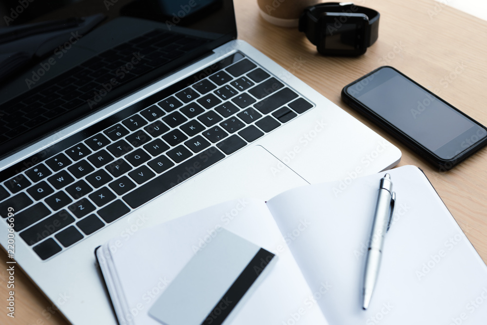 laptop, smartphone, smartwatch and blank notebook with pen and credit card on wooden table laptop, smartphone, smartwatch and blank notebook with pen and credit card on wooden table