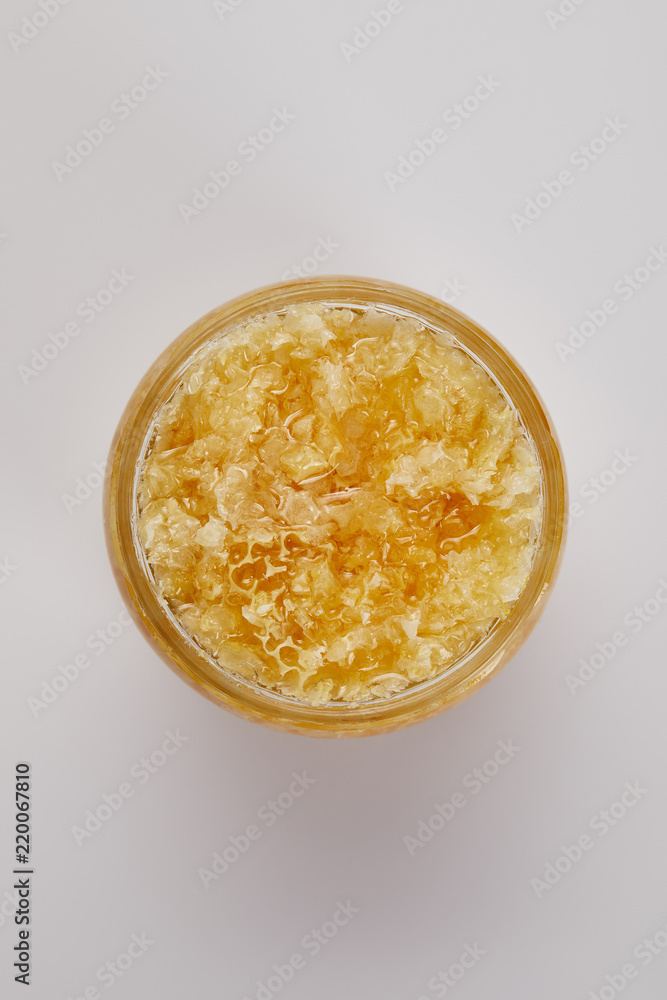 top view of glass jar with natural honey on grey tabletop top view of glass jar with natural honey on grey tabletop