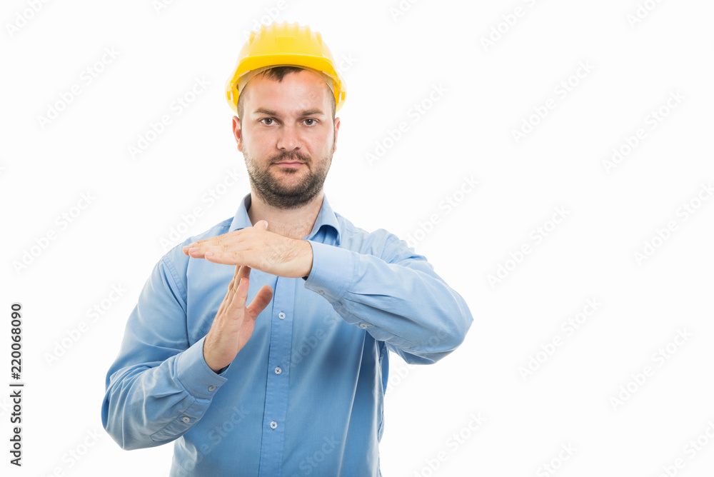 Young architect with yellow helmet showing time out gesture Young architect with yellow helmet showing time out gesture