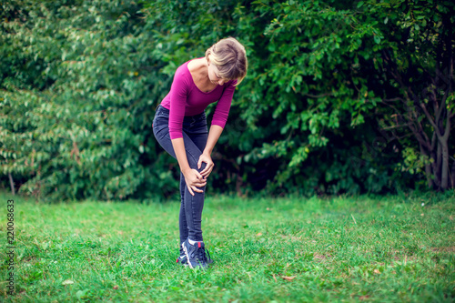 Healthcare concept. Woman suffering from pain in knee outdoor