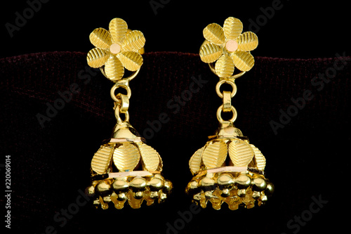 Golden earrings on a dark pattern