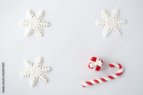 New year or christmas white background with a candy cane  a snowflake  a red box. Top view.