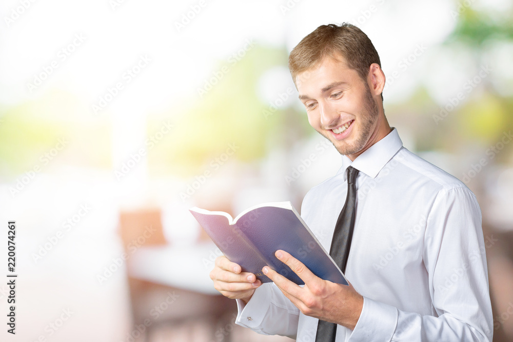 Handsome young business man reading a book Handsome young business man reading a book