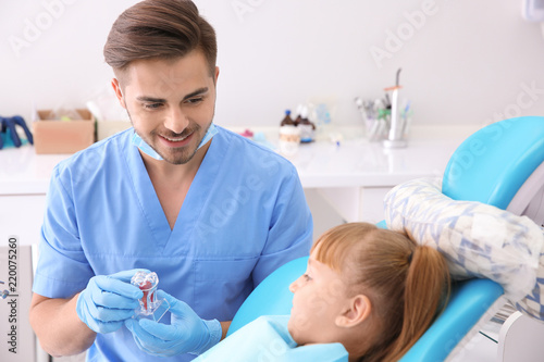 Cute little girl and dentist in clinic