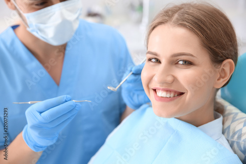 Dentist examining patient's...
