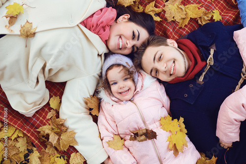 Happy family playing in the autumn in a park.
