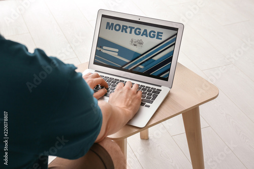 Man using laptop to pay mor...