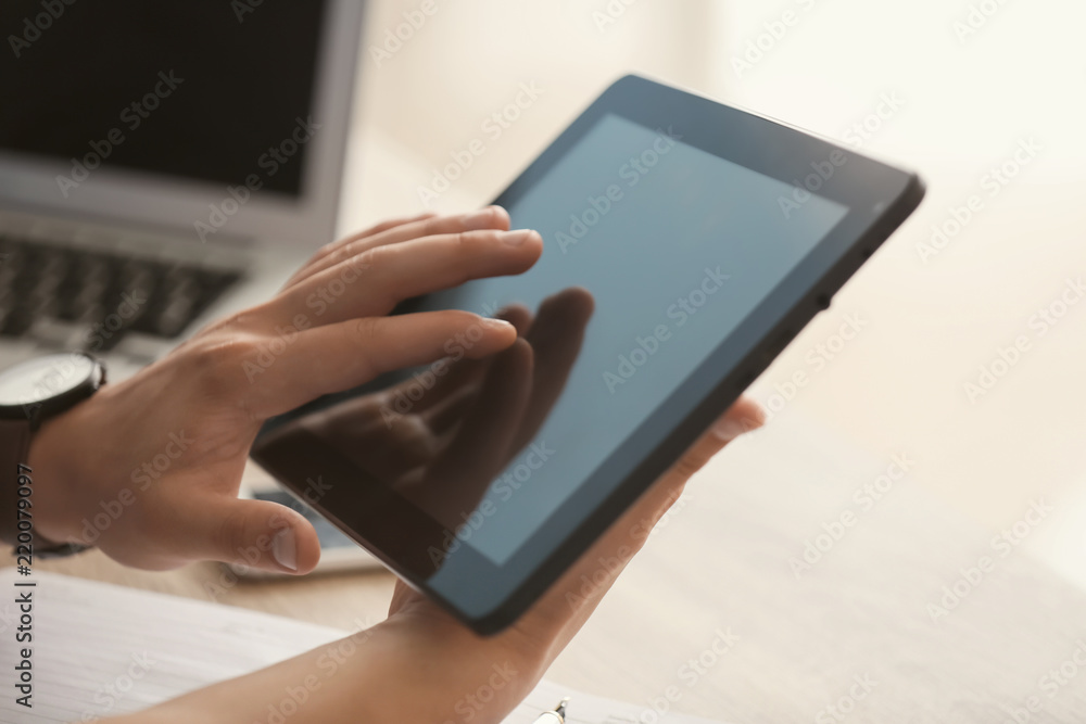 Young freelancer working on tablet computer at home, closeup