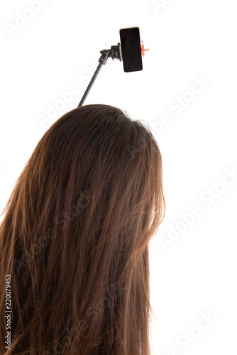 Back view of women to make a selfie stick portrait  on white background. photo