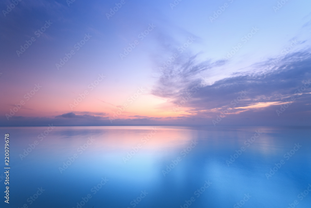 Obraz premium wschód słońca na wodzie / Wczesnym latem rano jasne niebo Plaża