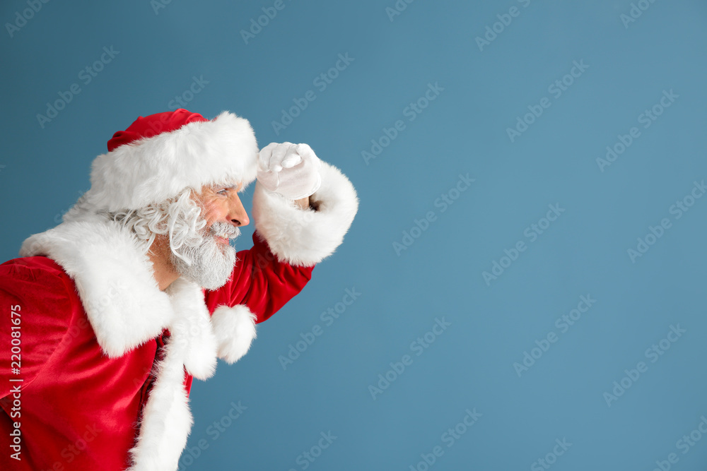 Portrait of Santa Claus looking far away on color background
