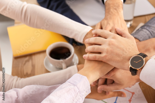 Business team putting hands together as symbol of unity