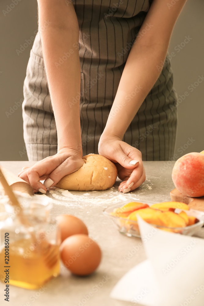 Woman preparing dough for peach galette at table