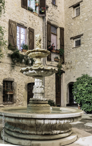 Patio with fountain in the old village at night, France. © arbalest