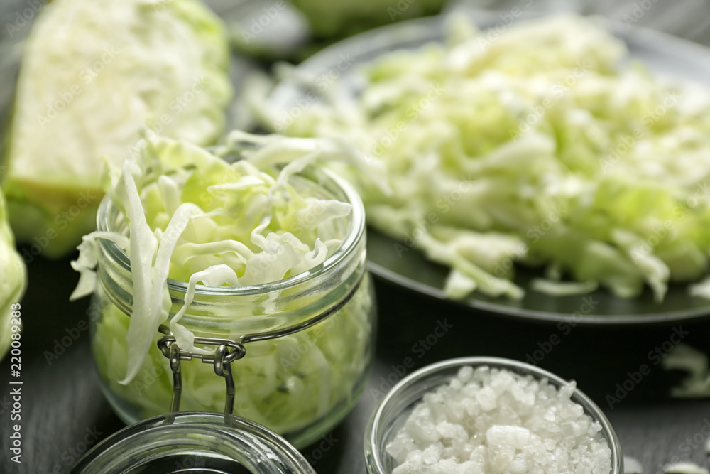 Glass jar with cut cabbage on table, closeup Glass jar with cut cabbage on table, closeup