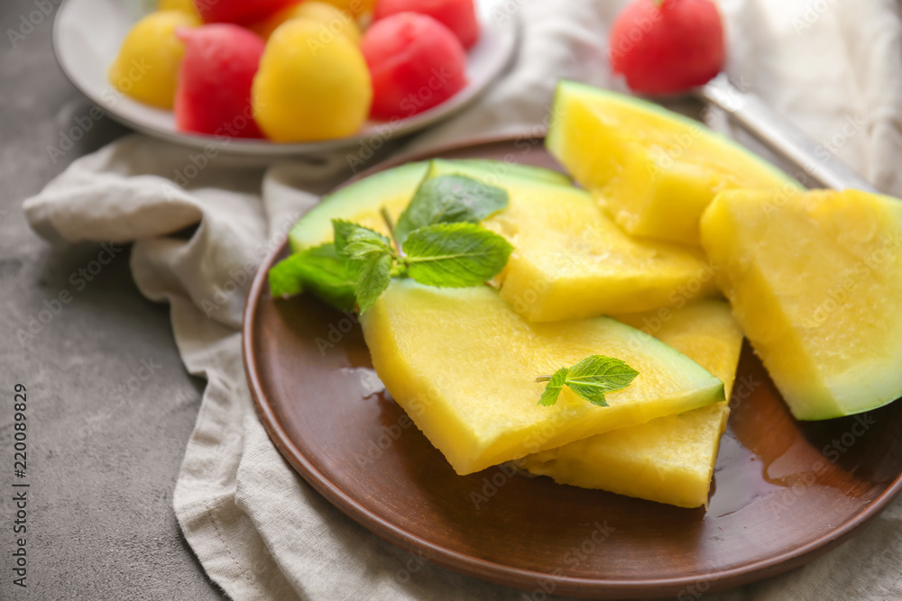 Plate with slices of yellow watermelon on dark table Plate with slices of yellow watermelon on dark table