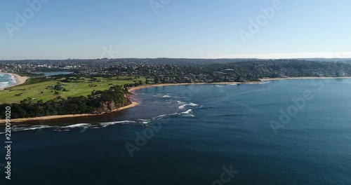 Sydney Northern beaches coast around Long Reef and Collaroy beach in aerial hovering North to South from open sea towards waterfront and plateau.
 photo