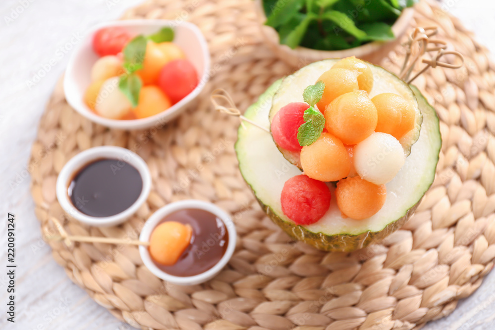 Tasty melon dessert with balls on wicker mat Tasty melon dessert with balls on wicker mat