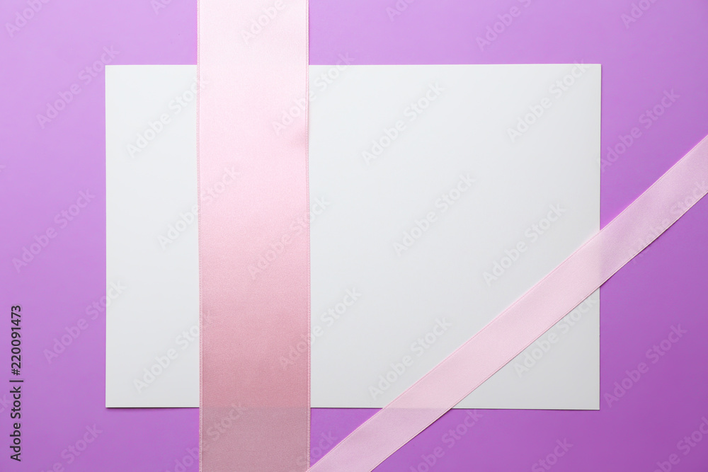 Blank paper card with pink ribbons on color background Blank paper card with pink ribbons on color background