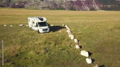4k aerial shot wooden campervans by countryside road heading to stunning valley